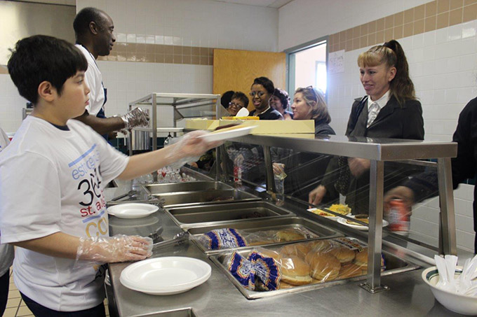 Miguel Pulido serves members of Holy Cross Catholic Church breakfast following a recent Mass. Knight David Small, in the background, helps serve. (David Sedeño/Texas Catholic)