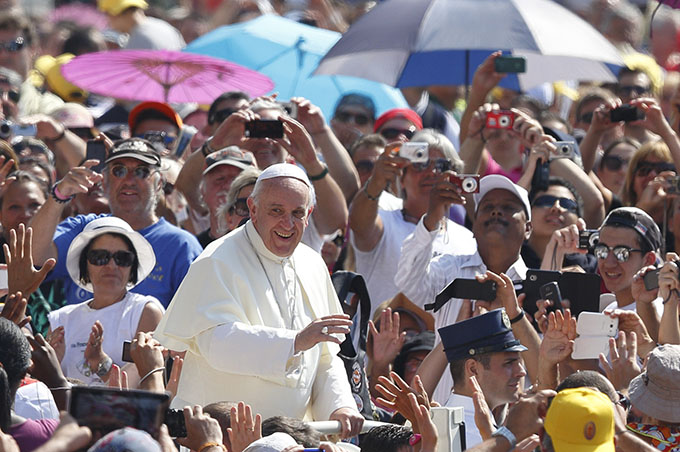 Pope Francis greets the crowd as he arrives to celebrate Mass in St. Peter's Square at the Vatican. The Year of Faith Mass concluded a weekend of events calling attention to care for the aged, the sick, the unborn and those with disabilities. (CNS photo/Paul Haring)