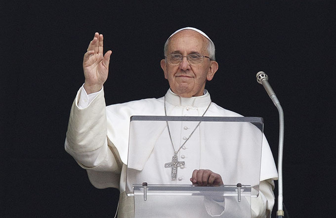 Pope Francis greets the crowd upon arriving to lead the Angelus from the window of his apartment overlooking St. Peter's Square at the Vatican. (CNS photo/Paul Haring)