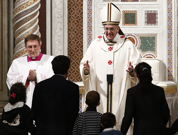 Pope Francis greets a family as he celebrates Mass at the Basilica of St. John Lateran in Rome. (CNS photo/Paul Haring)