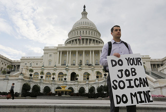 Furloughed federal employee holds sign on steps of U.S. Capitol after partial government shutdown