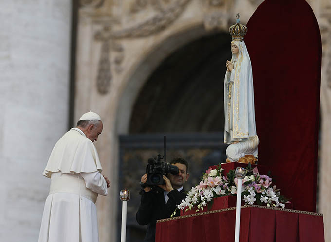 Pope Francis prays in front of the original statue of Our Lady of Fatima during a Marian vigil in St. Peter's Square at the Vatican Oct. 12. The statue was brought from Portugal for a weekend of Marian events culminating in Pope Francis consecrating the world to Mary. (CNS photo/Paul Haring)