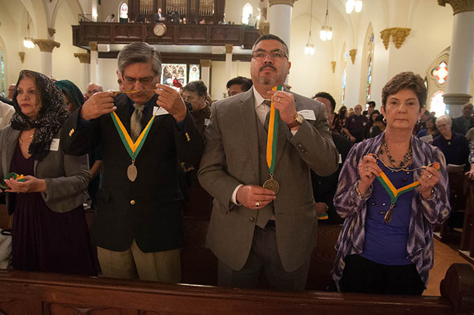 Diocese of Dallas volunteers, from left, Flor Chavira and Jesus Chavira of Divine Mercy of Our Lord Catholic Church in Mesquite, Johnny Ramos and Ann Marie Shubert of Good Shepherd Catholic Parish in Garland hold up their Bishop’s Award medals to be blessed by Bishop Kevin J. Farrell during Mass at the Cathedral Shrine of the Virgin of Guadalupe on Feb. 22. (JENNA TETER/The Texas Catholic)