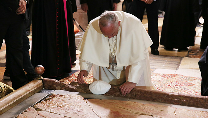 Pope Francis kneels before the Stone of Unction in Jerusalem's Church of the Holy Sepulcher May 25. The pope and Ecumenical Patriarch Bartholomew of Constantinople marked the 50th anniversary of the meeting in Jerusalem between Pope Paul VI and Patriarch Athenagoras. (CNS photo/Grzegorz Galazka)