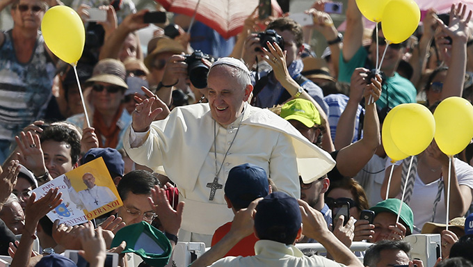 Pope Francis greets the crowd as he arrives to lead a general audience in St. Peter's Square at the Vatican. (CNS photo/Paul Haring)