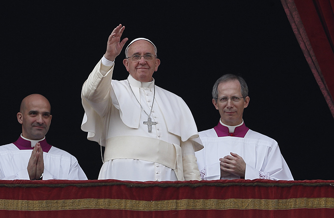 Pope Francis waves after delivering his Christmas blessing "urbi et orbi" (to the city and the world) from the central balcony of St. Peter's Basilica at the Vatican Dec. 25. (CNS photo/Paul Haring)