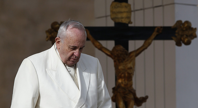 Pope Francis passes a crucifix during his general audience in St. Peter's Square at the Vatican Dec. 3. (CNS photo/Paul Haring)