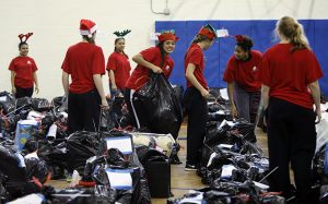Bishop Lynch High School junior Evelyn Escuadra lifts a bag of toys for a family in need during the Catholic Charities event. (Ben Torres/Special Contributor)