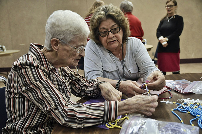 Parishioner Micaela Olivarez, right, shows Philomena Mattingly, how to put together a holiday rosary at Holy Spirit Catholic Church in Duncanville on Dec. 2. (JENNA TETER/The Texas Catholic)