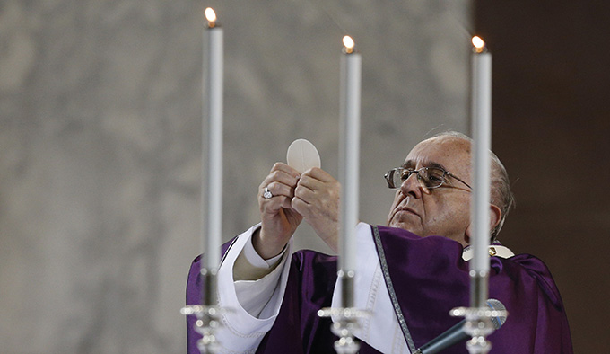 Pope Francis elevates the Eucharist during Ash Wednesday Mass at the Basilica of Santa Sabina in Rome Feb. 18. (CNS photo/Paul Haring)