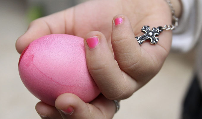 A girl holds a painted egg during celebrations after Easter Mass.