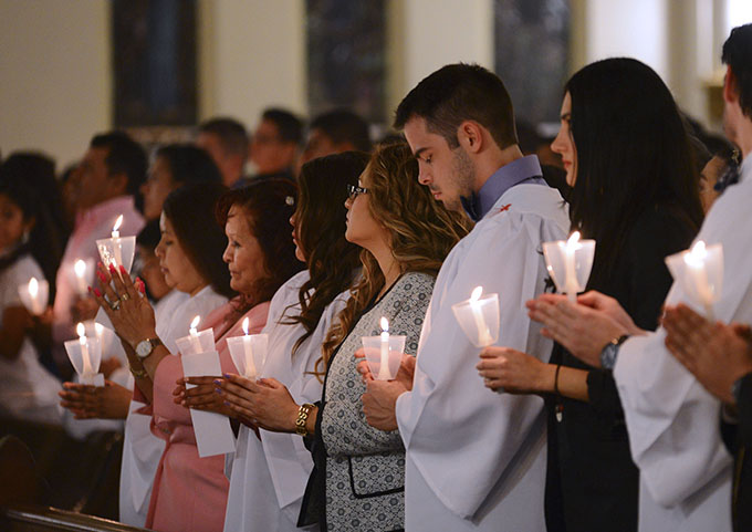 Baptism candidate Michael Fisher, middle, prepares to enter the Catholic Church on Holy Saturday at the Cathedral Shrine of the Virgin of Guadalupe at the Easter Vigil. (JENNA TETER/The Texas Catholic)