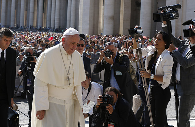 Pope Francis passes photographers and videographers as he arrives to lead his general audience in St. Peter's Square at the Vatican June 10. (CNS photo/Paul Haring)