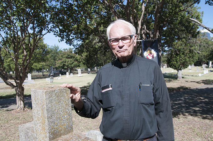 Father Timothy Gollob, pastor of Holy Cross Catholic Church in Oak Cliff, stands among the headstones in the historic Old Calvary Cemetery, located on N. Hall Street in Dallas. (JENNA TETER/The Texas Catholic)