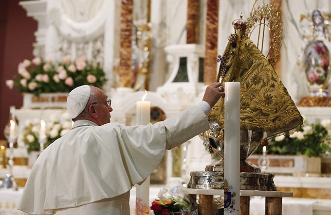 Pope Francis lights a candle at the statue of Our Lady of Charity, patroness of Cuba, in the Minor Basilica of the Shrine of Our Lady of Charity in El Cobre, Cuba, Sept. 21. (CNS photo/Paul Haring)