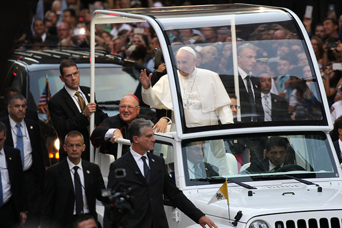 Pope Francis waves to the crowds as he approaches St. Patrick's Cathedral in New York City Sept. 24. Seated next to him is Cardinal Timothy M. Dolan of New York. (CNS photo/Gregory A. Shemitz)