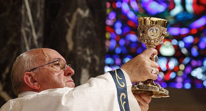Pope Francis raises the chalice of the Eucharist as he celebrates Mass with representatives from the Archdiocese of Philadelphia at the Cathedral Basilica of SS. Peter and Paul in Philadelphia Sept. 26. (CNS photo/Paul Haring)