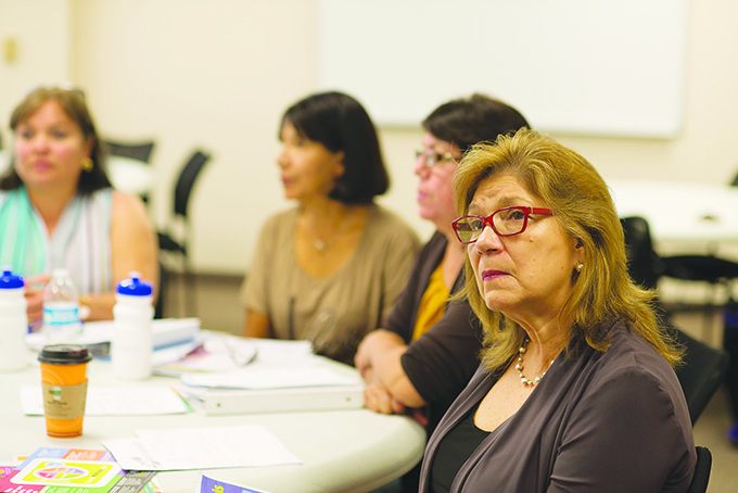 Eugenia Alexander, at right, listens to and watches a demostration on nutrition during a class of the “Getting Back on Our Feet” program at Catholic Charities Dallas Sept. 23. (JENNA TETER/The Texas Catholic)