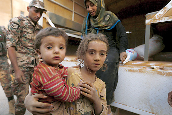 Syrian refugee children covered with dust arrive Sept. 10 at the Jordanian border with Syria and Iraq, near the town of Ruwaished, which is close to Amman, Jordan. (CNS photo/Muhammad Hamed, Reuters)