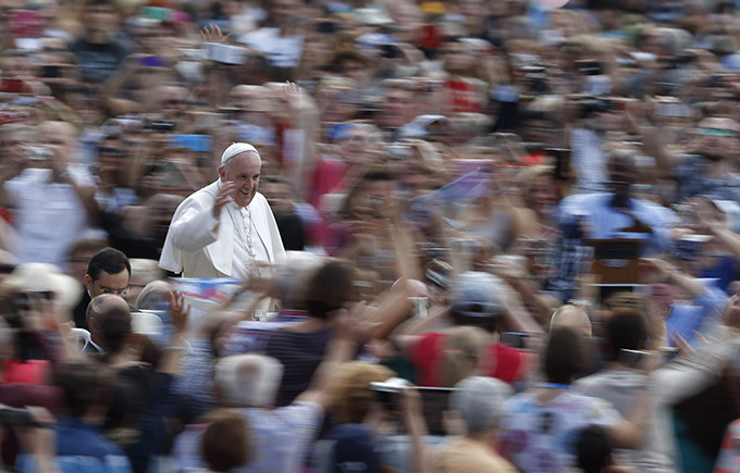 Pope Francis greets the crowd as he arrives to lead his general audience in St. Peter's Square at the Vatican Oct. 7. The pope said that when families mirror God's love for all, they teach the church how it should relate to all people. (CNS photo/Paul Haring)