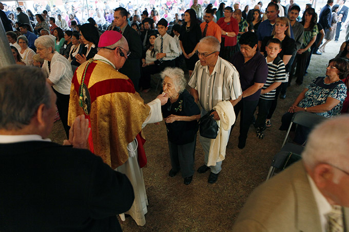 Bishop Kevin J. Farrell distributes communion to Nelly González during a special 125th Anniversary Mass for the Diocese of Dallas on Oct. 3 at Immaculate Conception Catholic Church in Corsicana, which has the distinction of being the oldest continuously operating parish in the diocese. (BEN TORRES/Special Contributor)