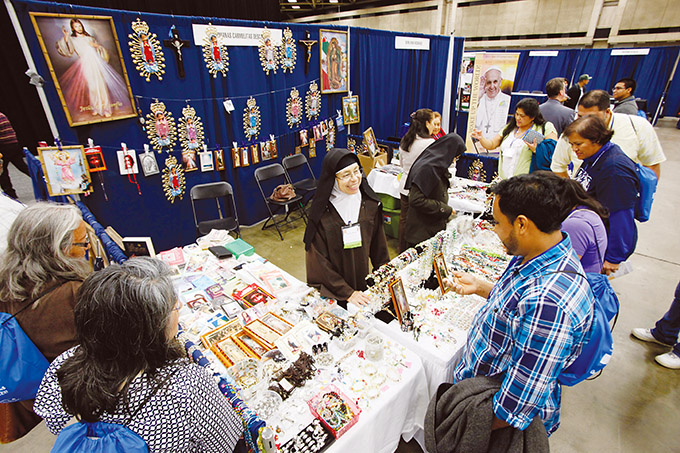 Blanca Maria Peña, of the Hermanas Carmelitas Descalsas, speaks with Antonio Ortiz, right, as he browses for a crucifix during the University of Dallas Ministry Conference 2015, on Oct. 24 at the Kay Bailey Hutchison Convention Center in Dallas. (Ben Torres/Special Contributor)
