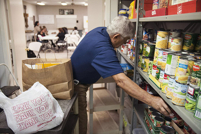 Tom Germino, president of the St. Vincent de Paul Conference at St. Francis of Assisi Catholic Church, collects items listed on an order form to put into a food bag for a client in the food pantry in Lancaster. (JENNA TETER/The Texas Catholic)