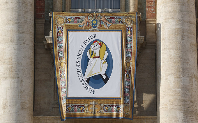 The logo for the Holy Year of Mercy is seen on a banner on the facade of St. Peter's Basilica at the Vatican Dec. 9. (CNS photo/Paul Haring)