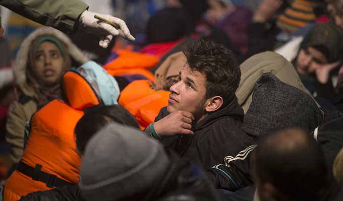 Members of the Turkish Coast Guard near Izmir, Turkey register Syrian migrants after capturing a boat carrying them Dec. 10 as they attempted to reach Greek island of Chios. (CNS photo/Tolga Bozoglu, EPA)