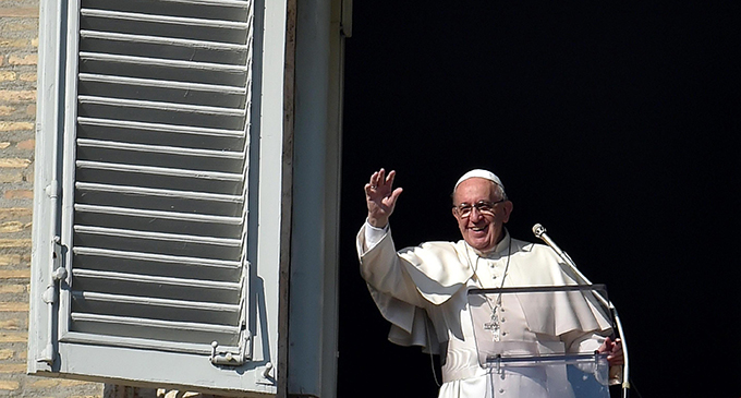 Pope Francis waves as he leads the Angelus from the window of his studio overlooking St. Peter's Square at the Vatican Dec. 27. (CNS photo/Ettore Ferrari, EPA)