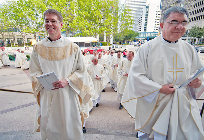 Father Don Zeiler, at left, and Father Eduardo Gonzalez join their brother priests as they process into the Chrism Mass at the Cathedral Shrine of the Virgin of Guadalupe on March 22.