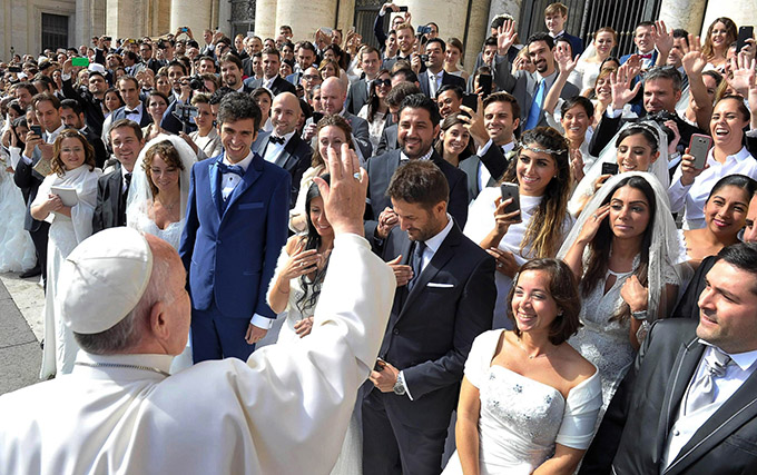 Pope Francis greets newly married couples during his general audience in St. Peter's Square at the Vatican in this Sept. 30, 2015, file photo. Pope Francis' postsynodal apostolic exhortation on the family, "Amoris Laetitia" ("The Joy of Love"), was to be released April 8. The exhortation is the concluding document of the 2014 and 2015 synods of bishops on the family. (CNS photo/L'Osservatore Romano)