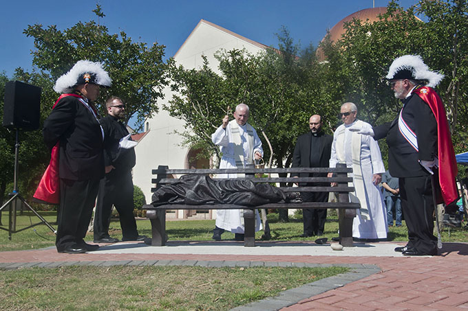 Father Kevin Wilwert, Msgr. Henry Petter, Father Paolo Capra and Msgr. Milam Joseph dedicate and bless the new “Homeless Jesus” statue at St. Ann Catholic Church in Coppell on April 30. (JENNA TETER/The Texas Catholic)