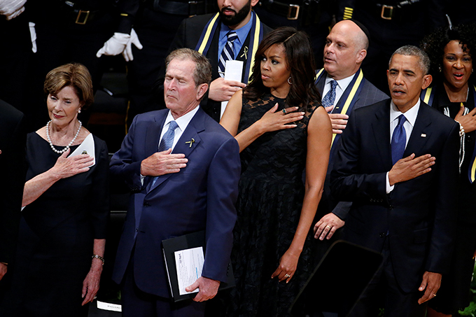 Former first lady Laura Bush, former U.S. President George W. Bush, first lady Michelle Obama and President Barack Obama hold their hands on their hearts as they sing the national anthem July 12 at a memorial service held in honor of police officers killed and wounded in shootings in Dallas. (CNS photo/Carlo Allegri, Reuters)