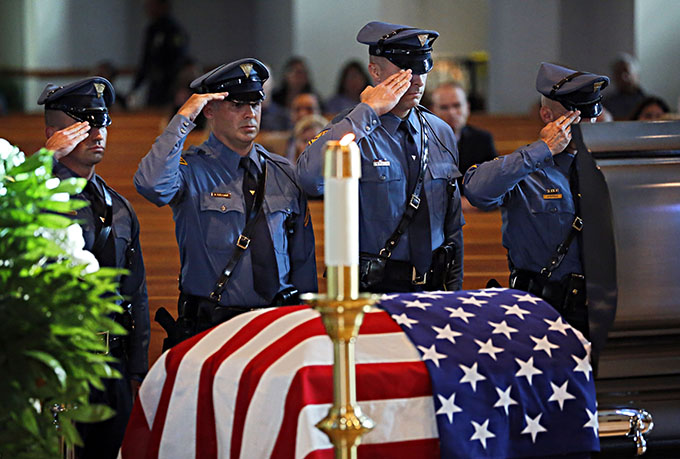 Members of the New Jersey State Police salute a casket with the body of slain Dallas police Sgt. Michael Smith during a visitation Tuesday, July 12, 2016 at Mary Immaculate Catholic Church in Farmers Branch, Texas. Smith was one of five officers killed last week when a gunman opened fire on a Black Lives Matter rally in downtown Dallas. (Pool photo/G.J. McCarthy/The Dallas Morning News)