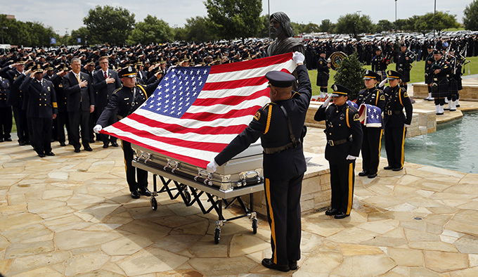 Dallas police Color Guard's Sr. Cpl. Josh Cooper (facing) and Sr. Cpl. Don Alexander prepare to fold the flag during a ceremony for officer Michael Krol outside of Prestonwood Baptist Church in Plano, Texas, Friday, July 15, 2016. Krol was gunned down in an ambush attack in downtown Dallas a week ago. Four Dallas police officers and one DART officer were killed and several survived. (Tom Fox/The Dallas Morning News, pool photo)