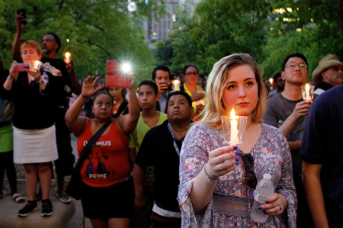 Candles are held during a vigil at city hall on July 11 in Dallas. (KEVIN BARTRAM/Special Contributor)