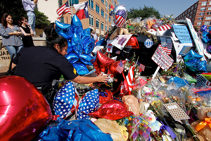 Dallas Police Department Sgt. Rocio Munoz inspects a memorial at police headquarters on July 11 in Dallas. (KEVIN BARTRAM/Special Contributor)