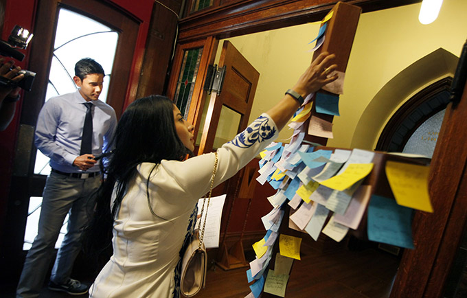 Parishioner Cassandra Hernandez leaves a message on a crucifix showing her support for the victims of the Black Lives Matter rally shooting, before the start of a Mass for Hope and Healing celebrated by Bishop Kevin J. Farrell, on July 9 at the Cathedral Shrine of the Virgin of Guadalupe in Dallas. (Ben Torres/Special Contributor)