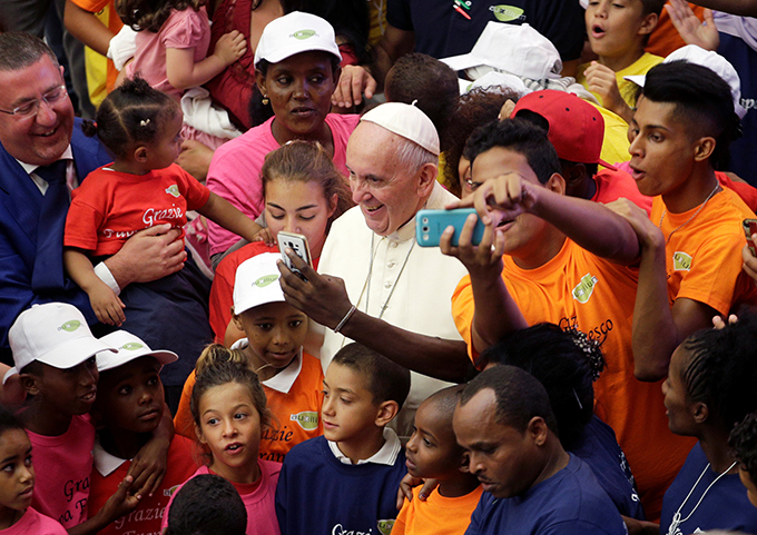 Pope Francis poses with refugees as he leads his general audience in Paul VI hall at the Vatican Aug. 3. (CNS photo/Max Rossi, Reuters)