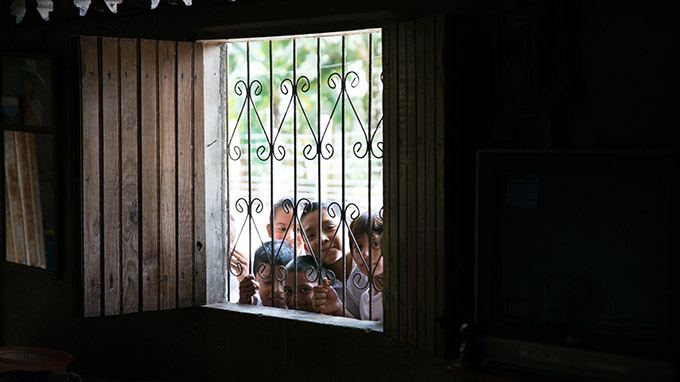 A group of children peek through a window at young adult missionaries from the Diocese of Dallas on July 14 in Muelle De Los Bueyes, Nicaragua. The missionaries spent a week Nicaragua, sharing their faith and assisting villagers with construction projects. (ZACHARY HARRIS/Special Contributor)