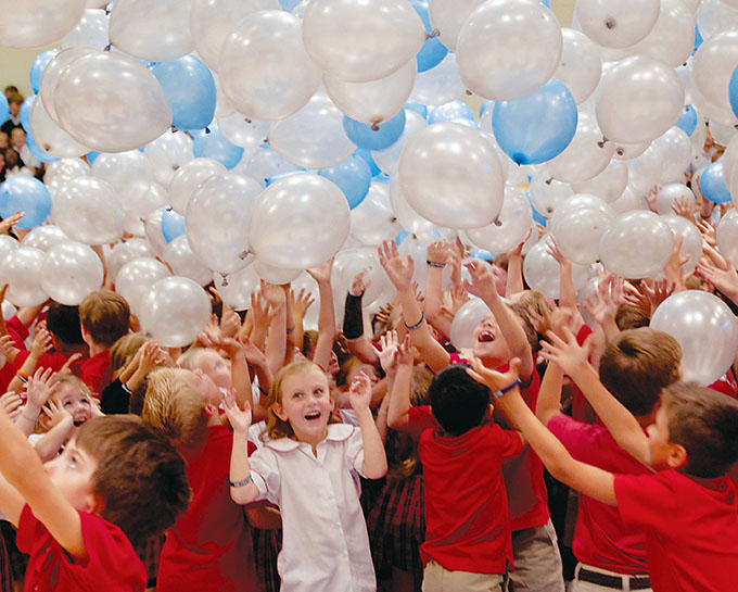 Students are surrounded by falling balloons as they gather to celebrate the announcement of Prince of Peace Catholic School in Plano as a 2016 National Blue Ribbon School by the U.S. Department of Education. (JENNA TETER/The Texas Catholic)
