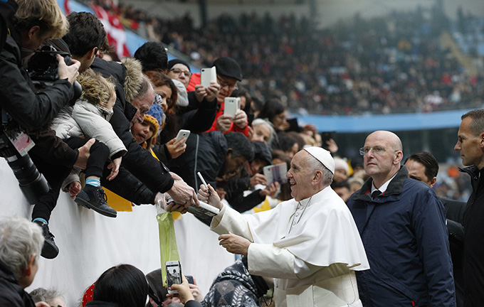 Pope Francis autographs a book before celebrating Mass at the Swedbank Stadium in Malmo, Sweden, Nov. 1. (CNS photo/Paul Haring)