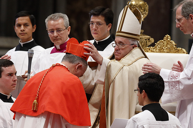 Pope Francis places a red biretta on new Cardinal John Dew of Wellington, New Zealand, during the 2015 consistory in St. Peter's Basilica at the Vatican. (CNS photo/Paul Haring)