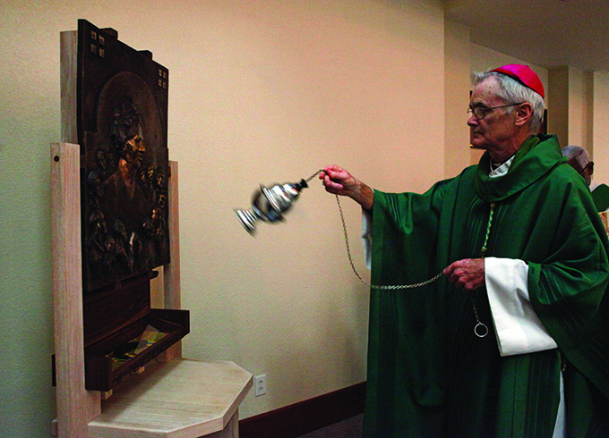 Bishop Greg Kelly makes a special blessing on a piece of art made to honor Sister Thea Bowman on Oct. 16 at Holy Cross Catholic Church. (Ben Torres/Special Contributor)
