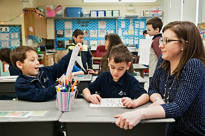 Principal Nicole Miller visits with students during an activity in their classroom at Holy Name Catholic School in Ketchikan, Alaska. (JENNA TETER/The Texas Catholic)