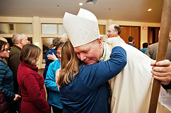 Bishop Edward J. Burns receives a hug from a well-wisher following his farewell Mass Jan. 19 at St. Paul Catholic Church in Juneau. (JENNA TETER/The Texas Catholic)