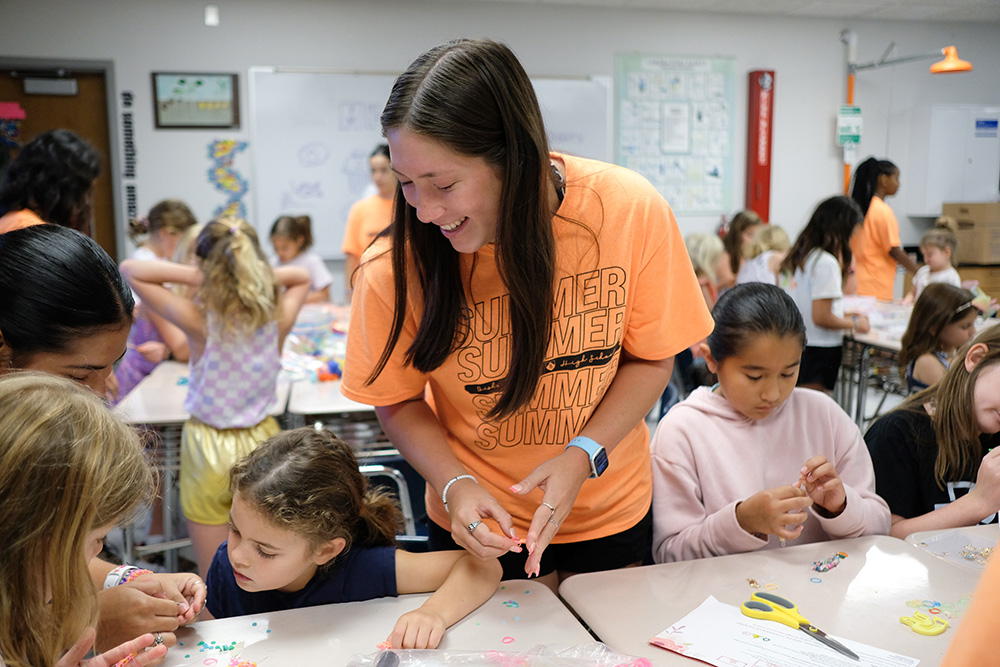 Adriana Medina sirve como consejera y ayuda a un grupo de niños a hacer manualidades en el campamento de Bishop Lynch, el 13 de julio.